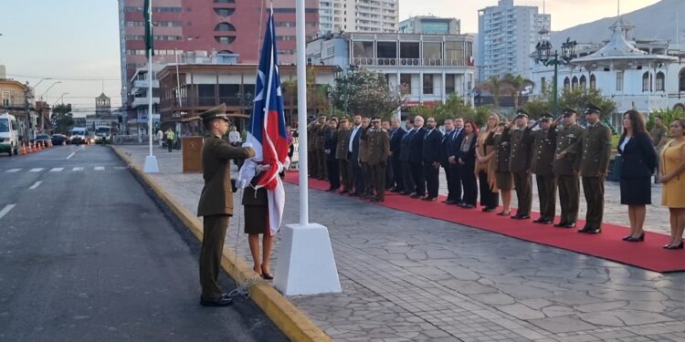 Carabineros junto a la comunidad realiza izamiento del Pabellón Nacional en Plaza Prat